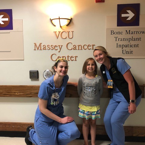 Lauren with two nurses standing in the hallway of the BMT unit