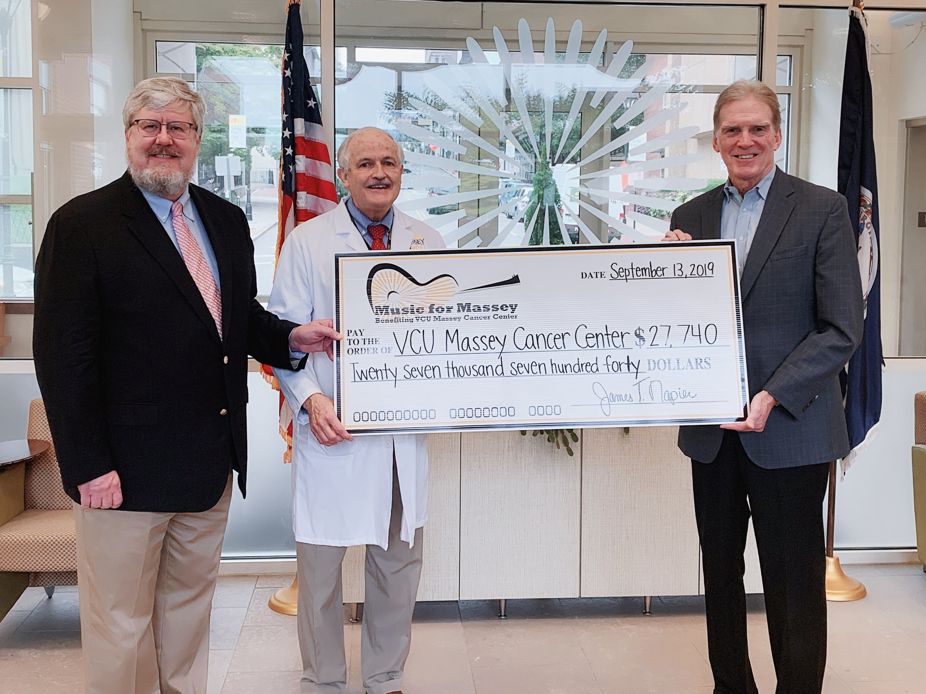 Two doctors receive a check from a fundraiser for Connor's Heroes