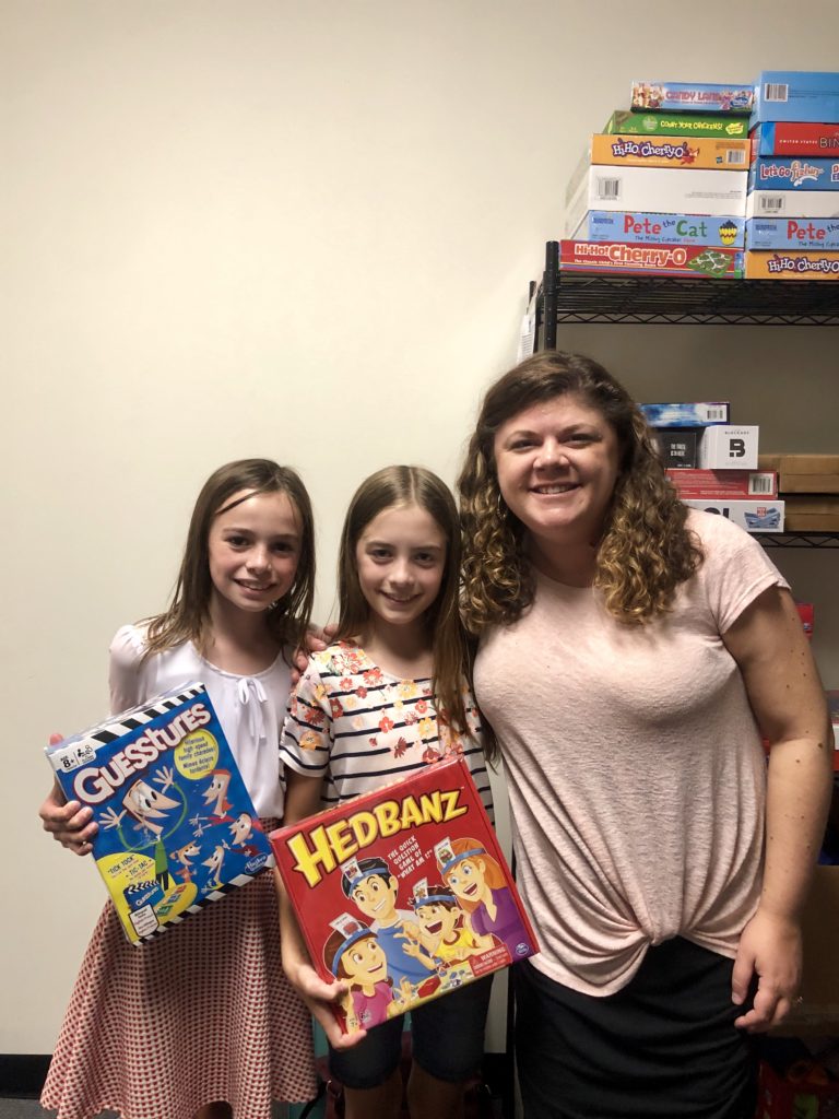 Two children hold games they donated for Connor's Heroes