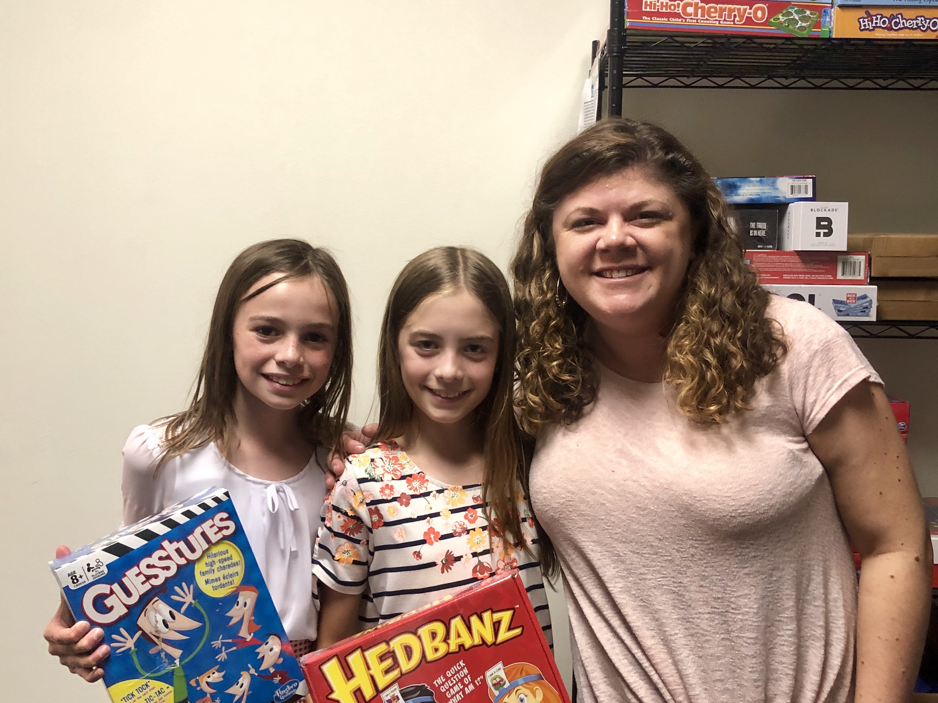 Two children hold games they donated for Connor's Heroes