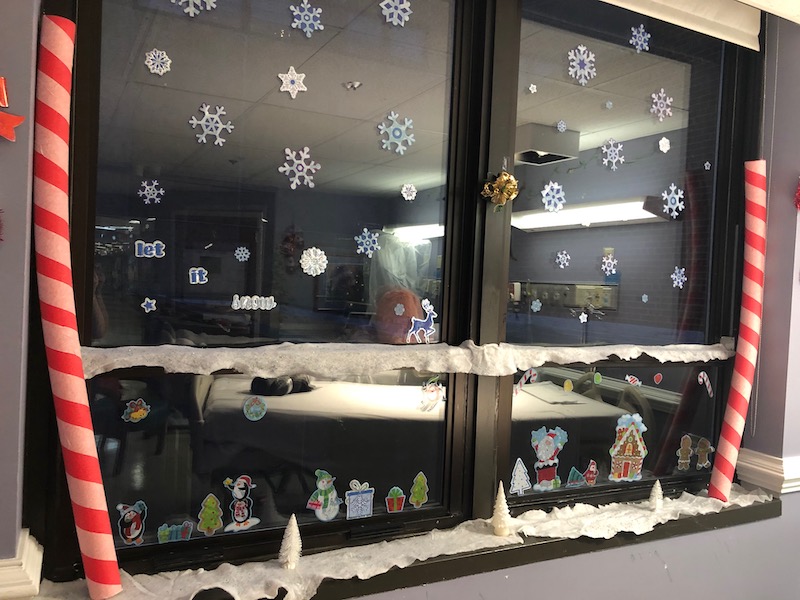 Hospital room window decorated with snowflakes and fake snow