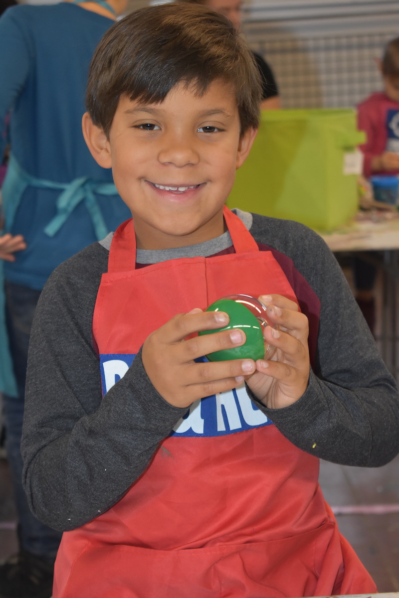 Boy holds the ornament he made at the Heroes Art Sessions