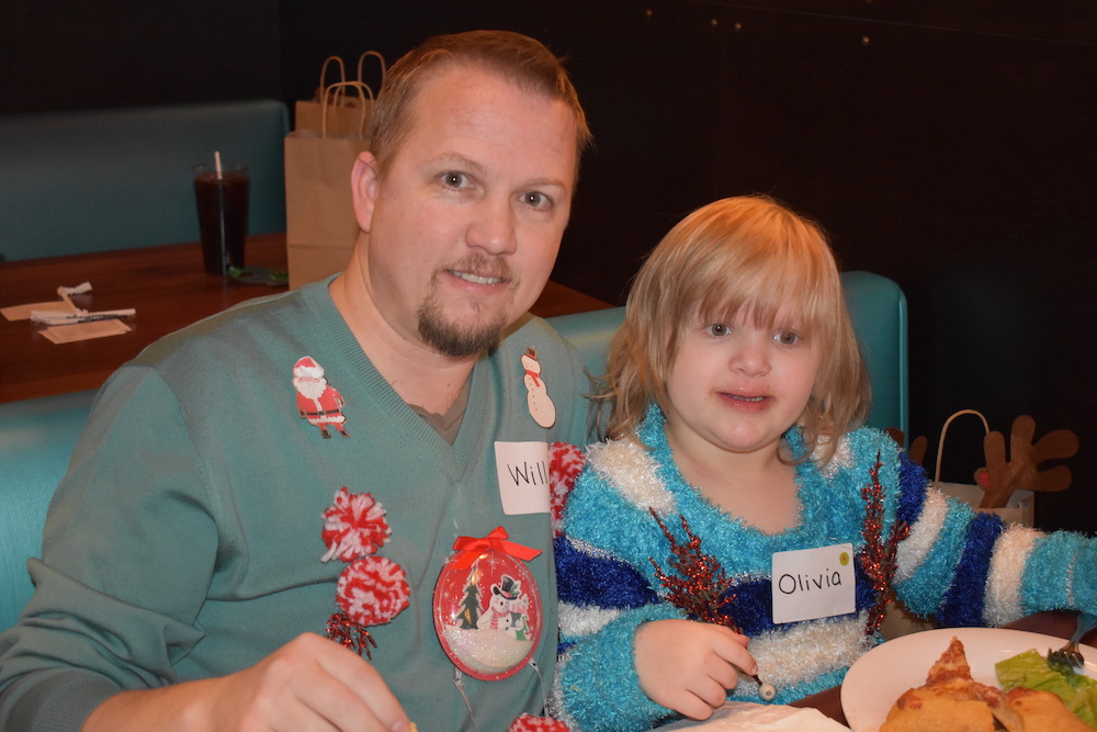 Dad and daughter eating pizza at holiday party