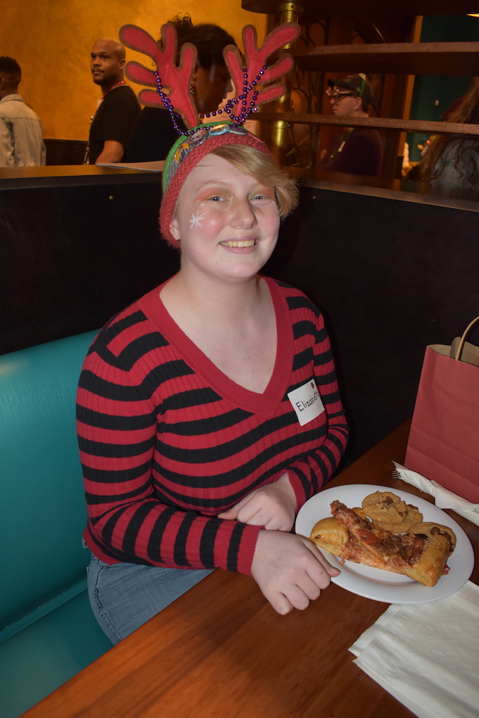 Teen eating pizza at holiday party