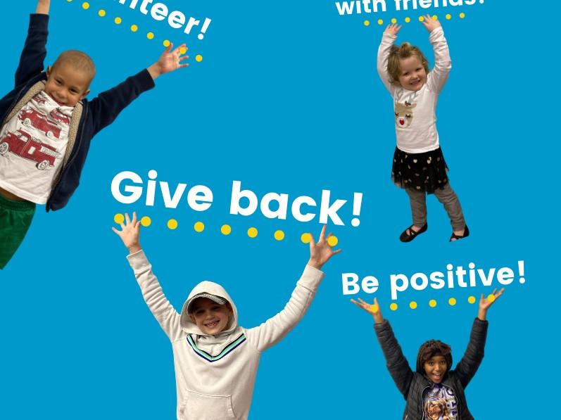 Four children with their hands in the air