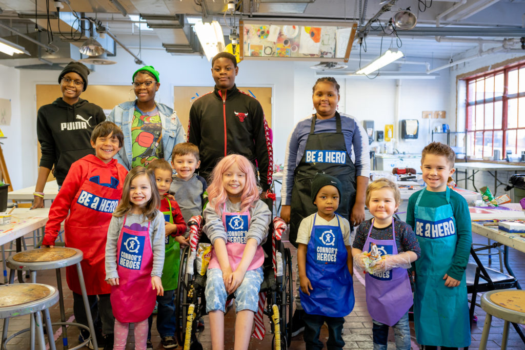 13 children posing together in an art studio