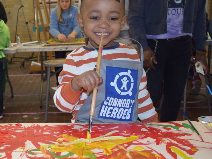 Boy painting a large canvas