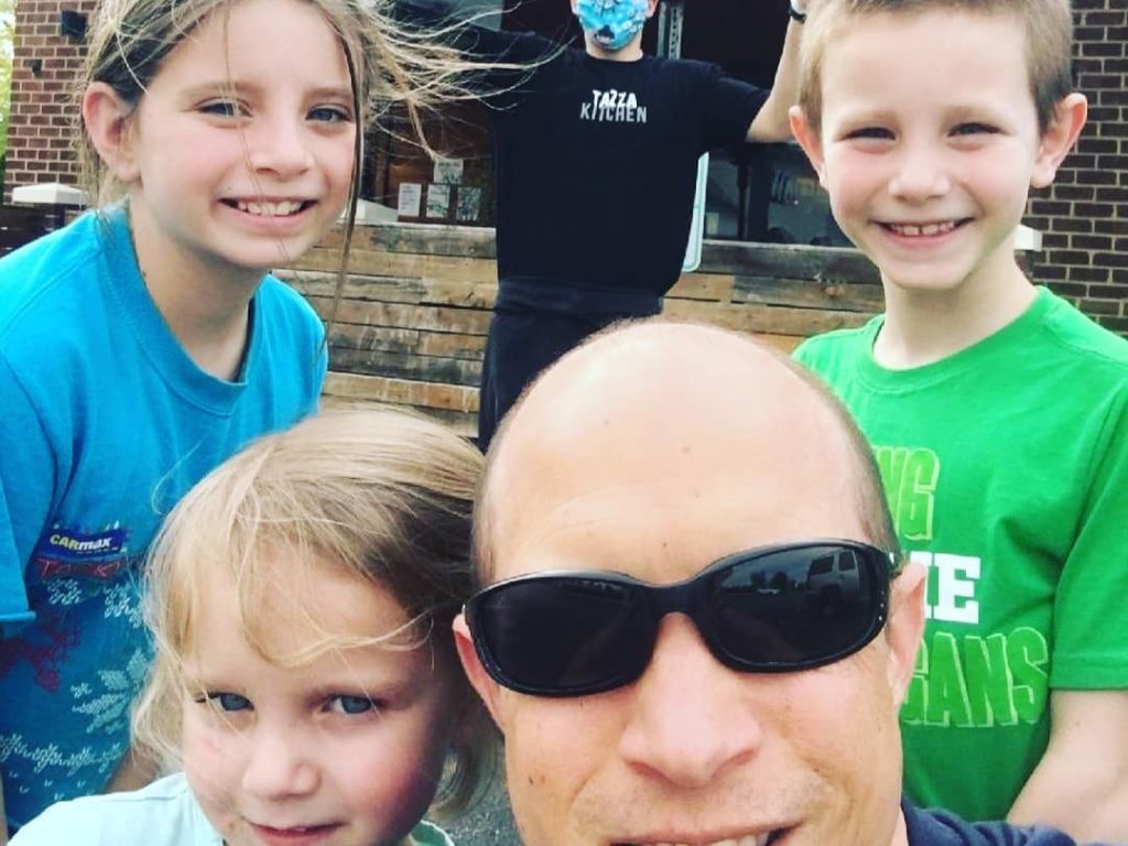 A family in front of a restaurant ready to deliver meals to families helped by Connor's Heroes.