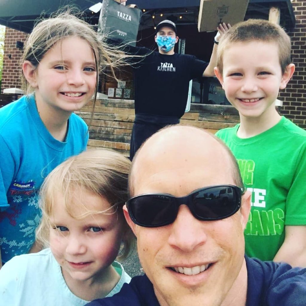 A family in front of a restaurant ready to deliver meals to families helped by Connor's Heroes.