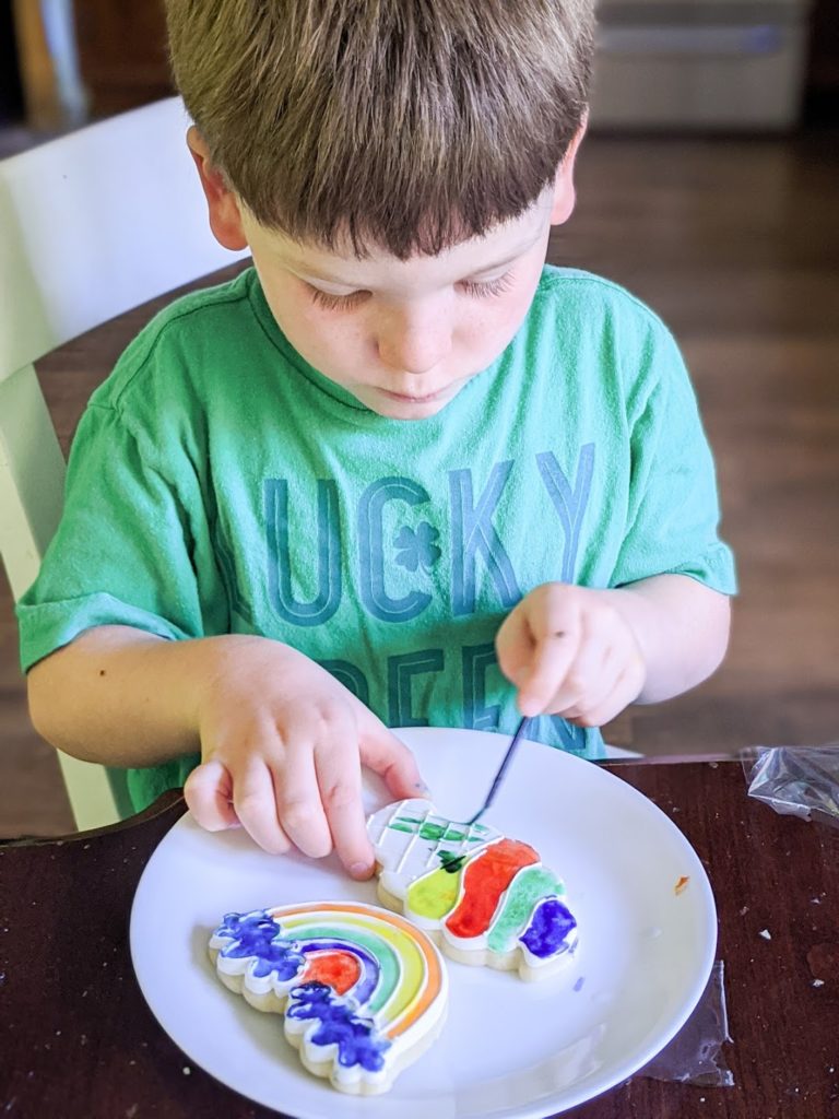 Child decorating two cookies