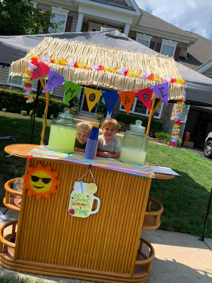 Two children selling lemonade outside
