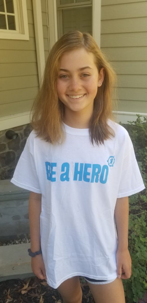 A child wearing a Be A Hero white t-shirt