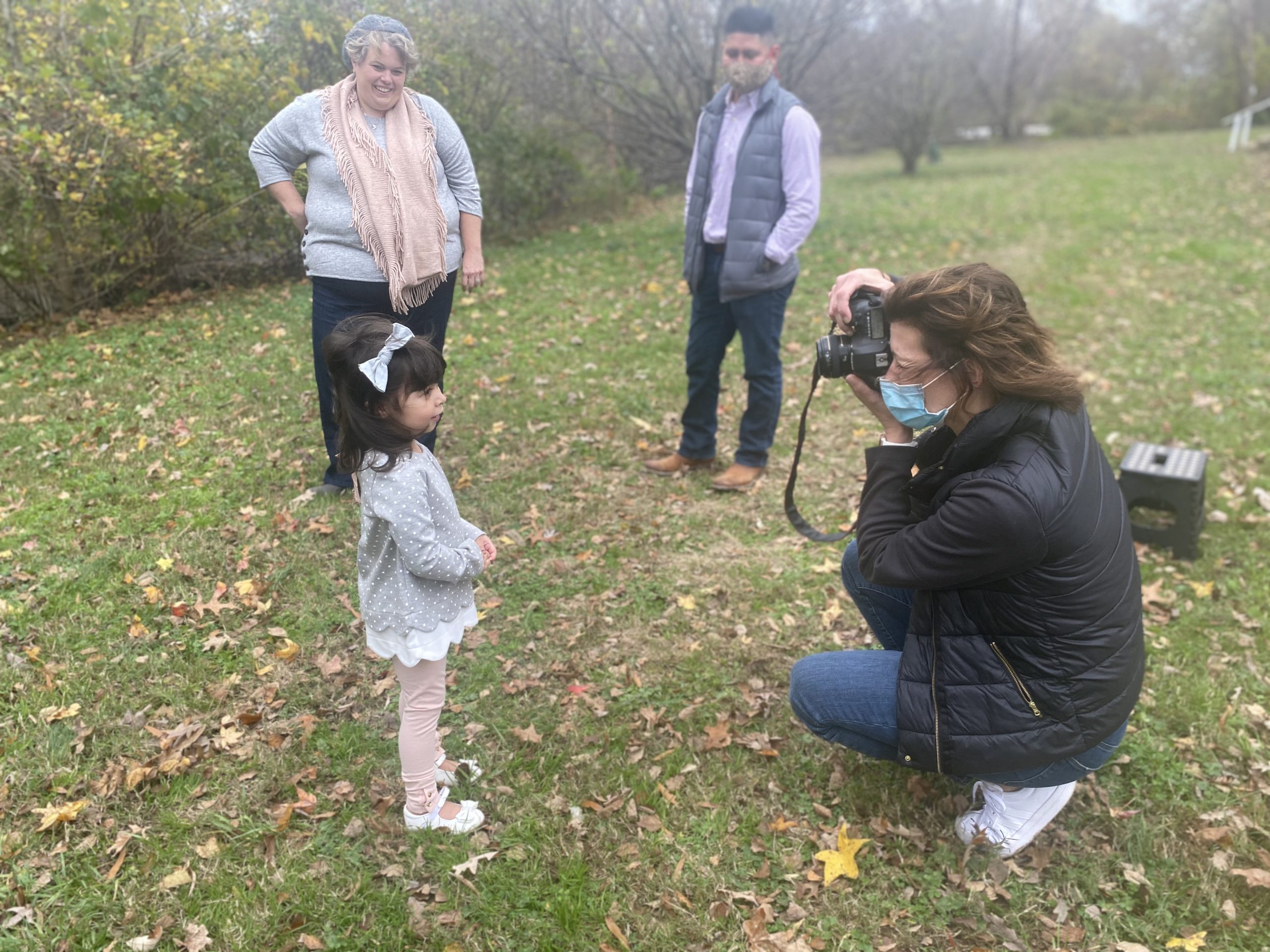 Photographer taking a photo of a family in a park