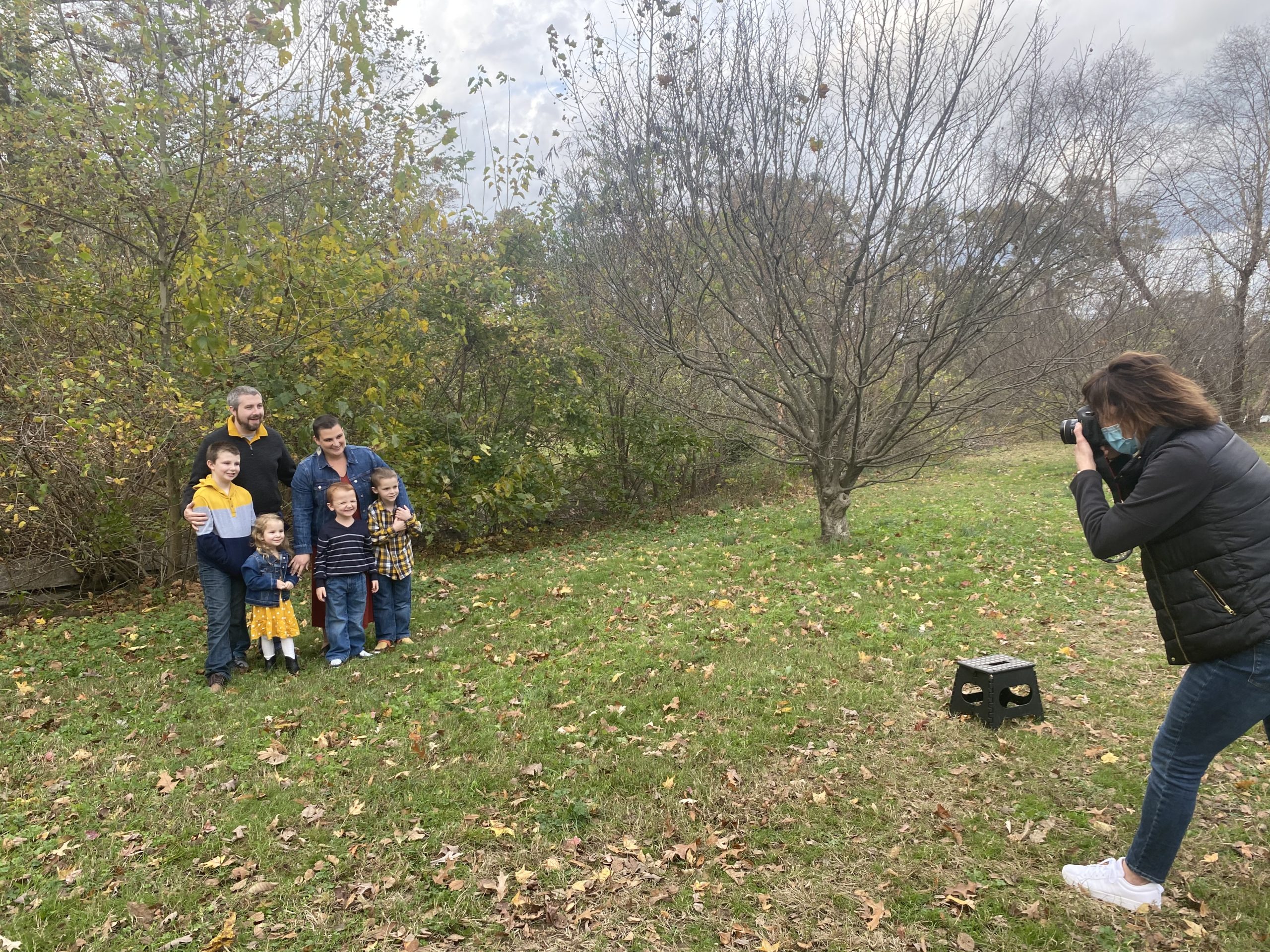 Photographer taking a photo of a family in a park