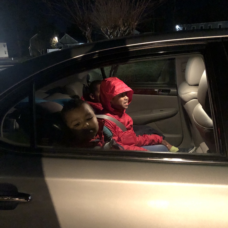 Two children sitting in the back seat of a car