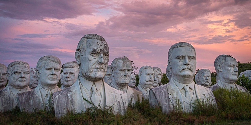 Image group of large-sized busts of US presidents sitting outside in a field