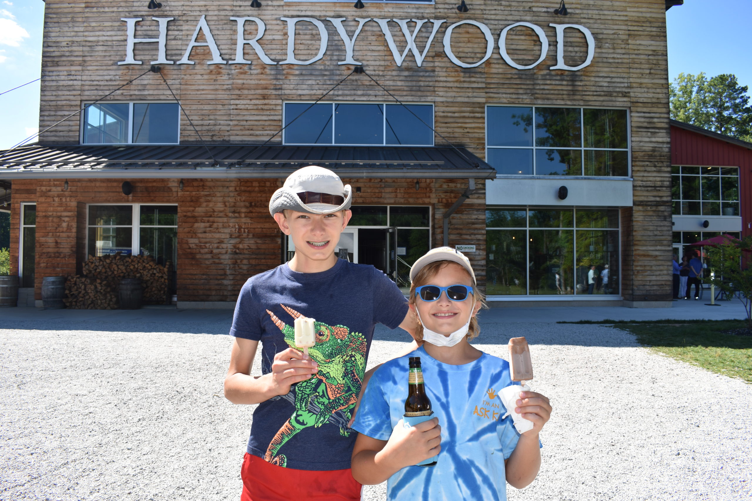 Image two children both wearing hats standing in front of the entrance of Hardywood