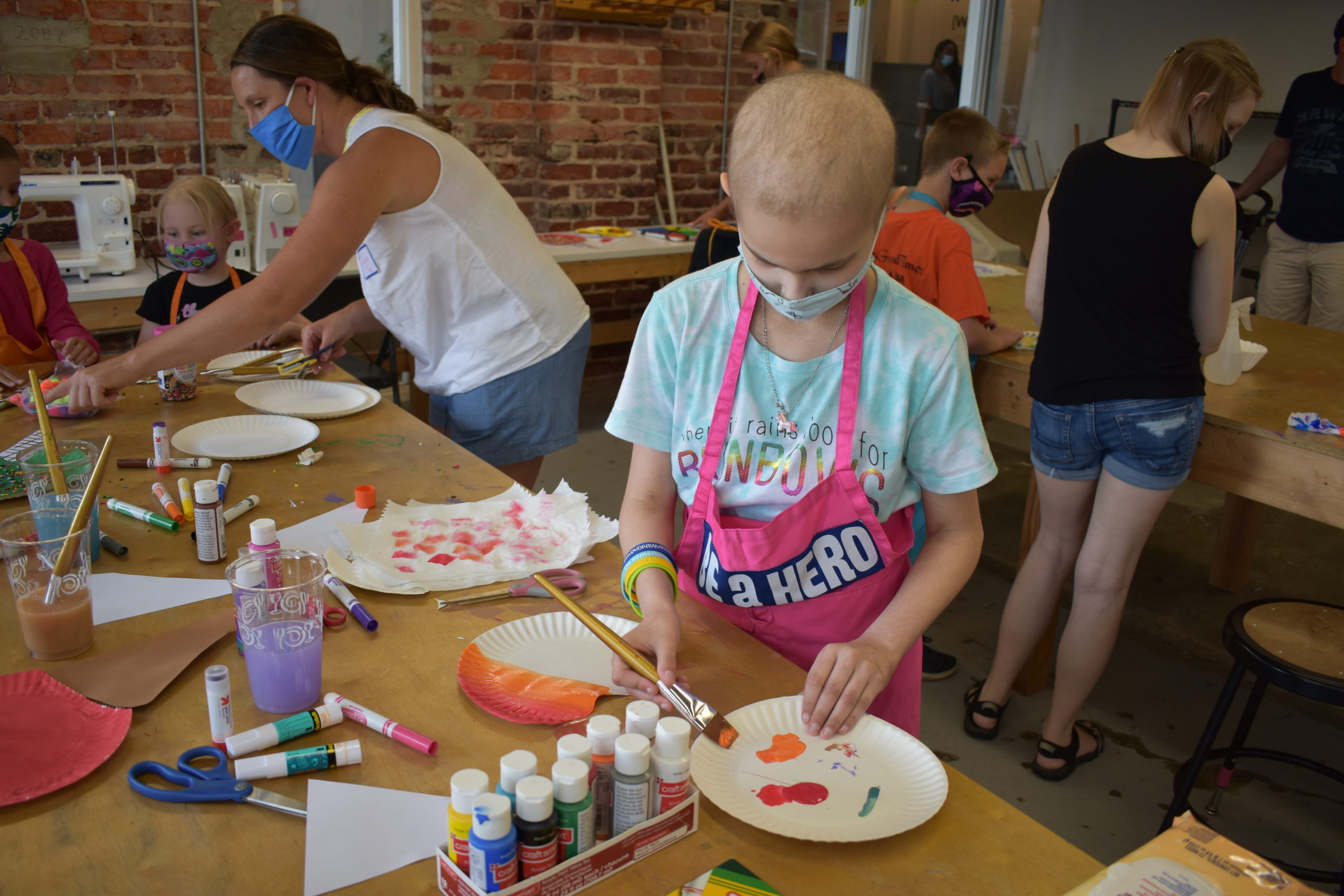 Image a child painting a paper plate in an art studio