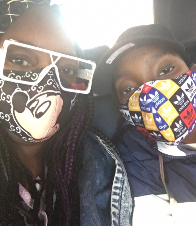 Image of a teenager wearing a mask sitting next to his mom who is wearing a mask
