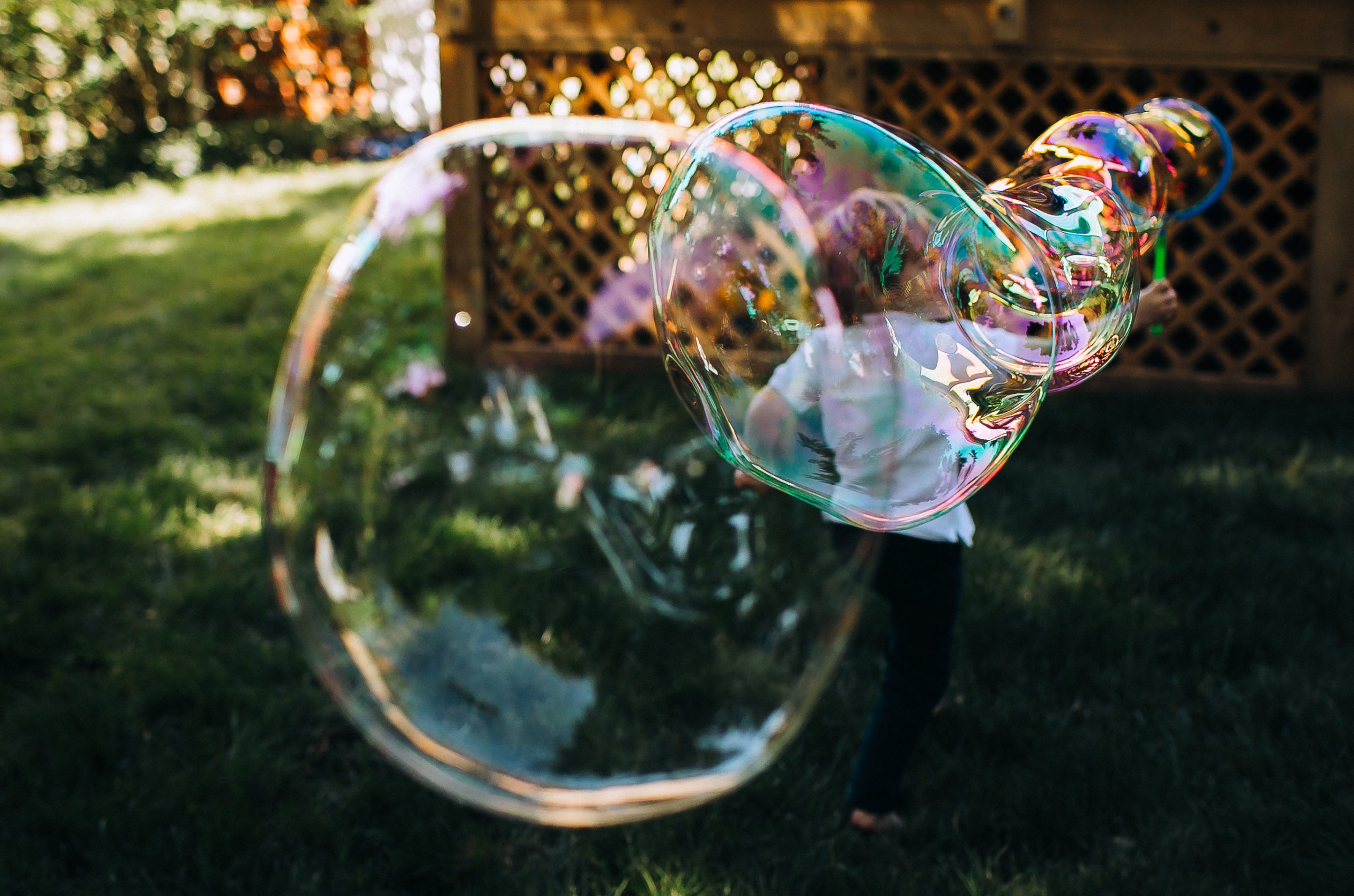 Image child running in a yard blowing bubbles