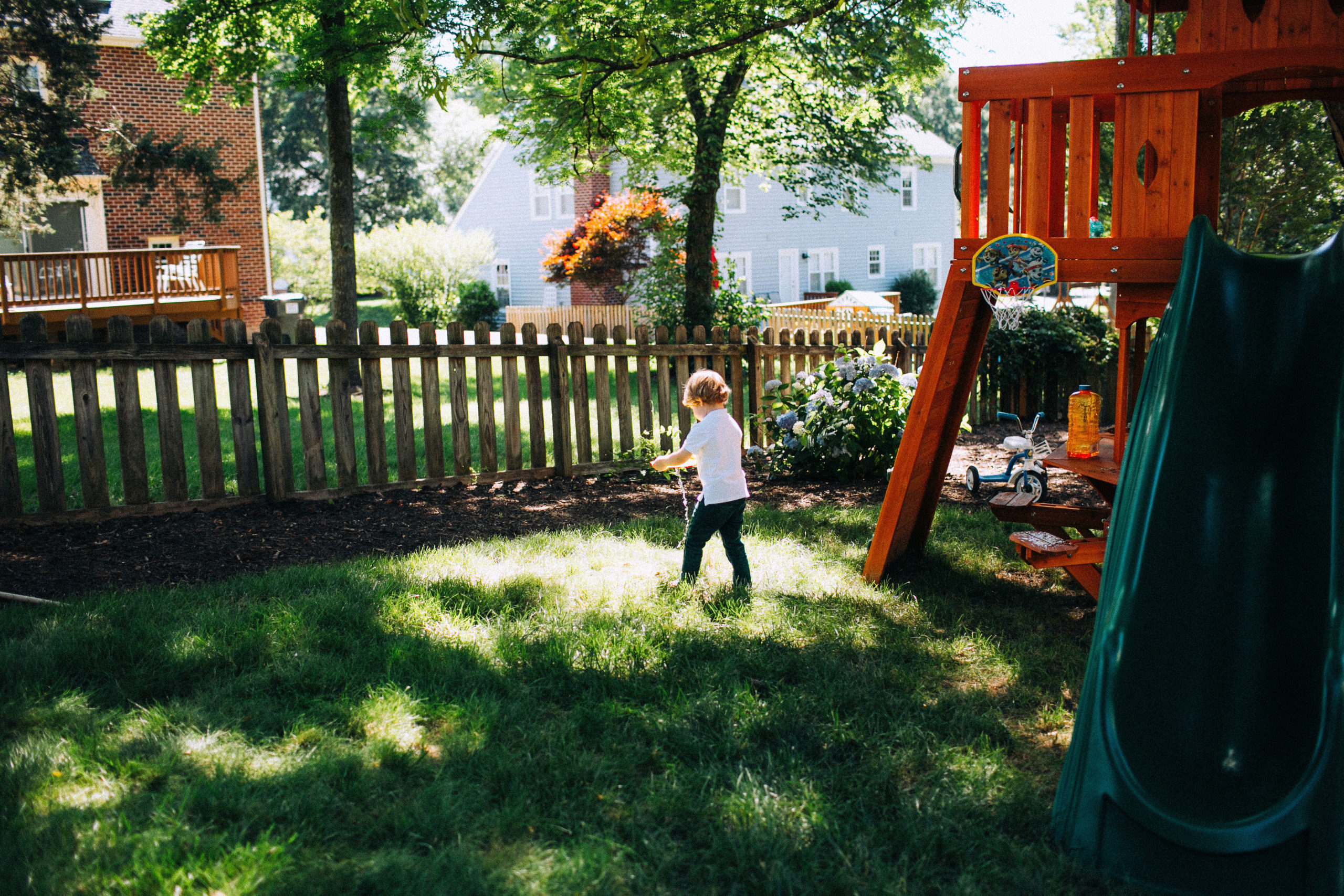 Image child in his back yard playing with a toy
