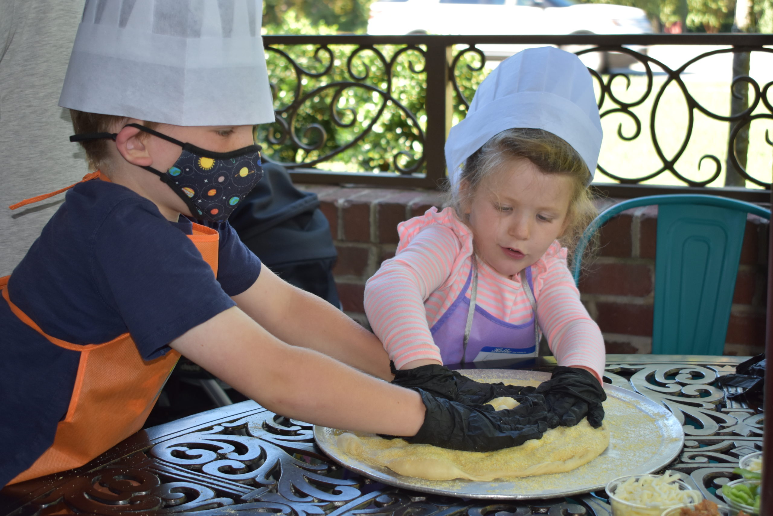 Image two children rolling pizza dough