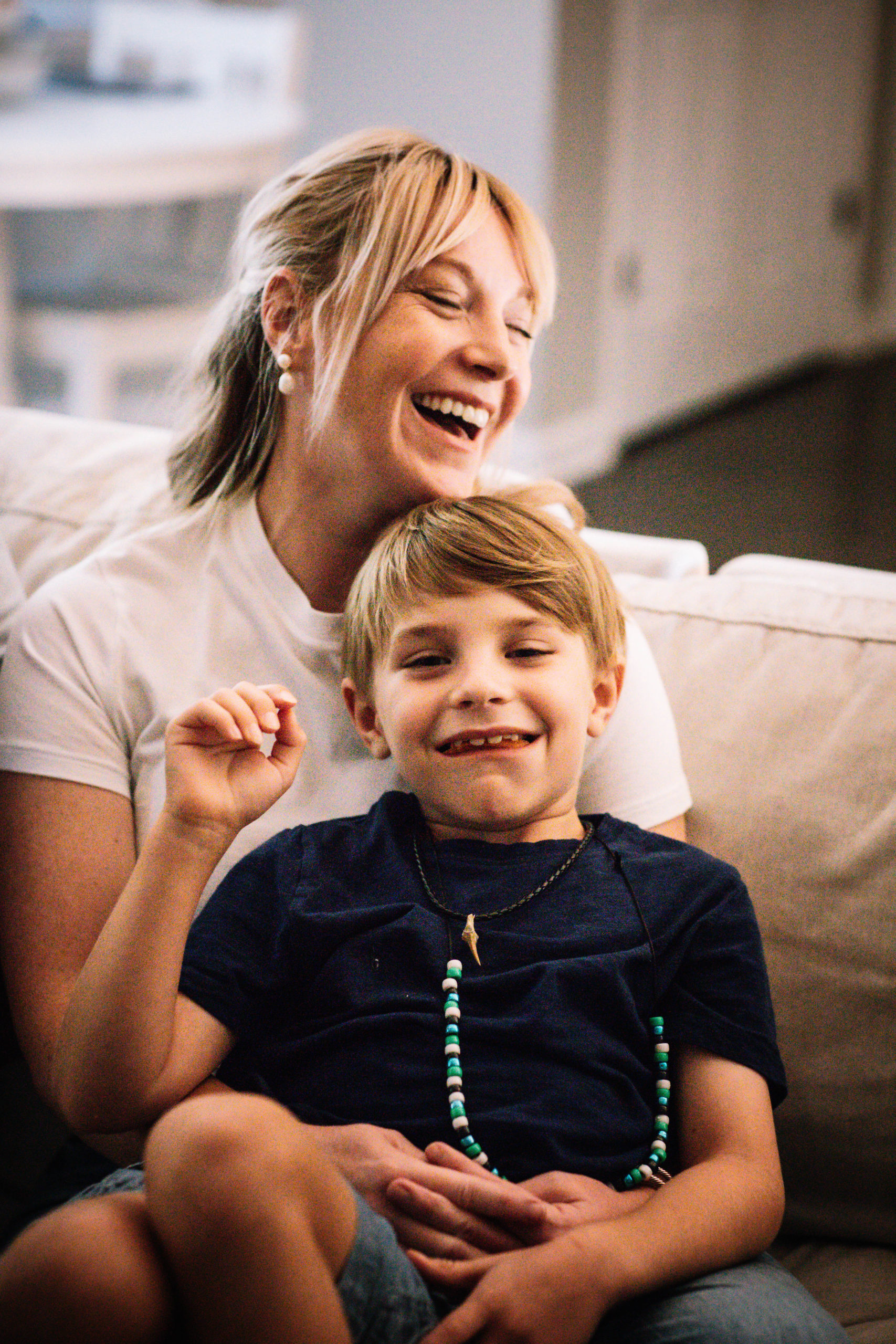 Image a parent sitting on her couch with her child