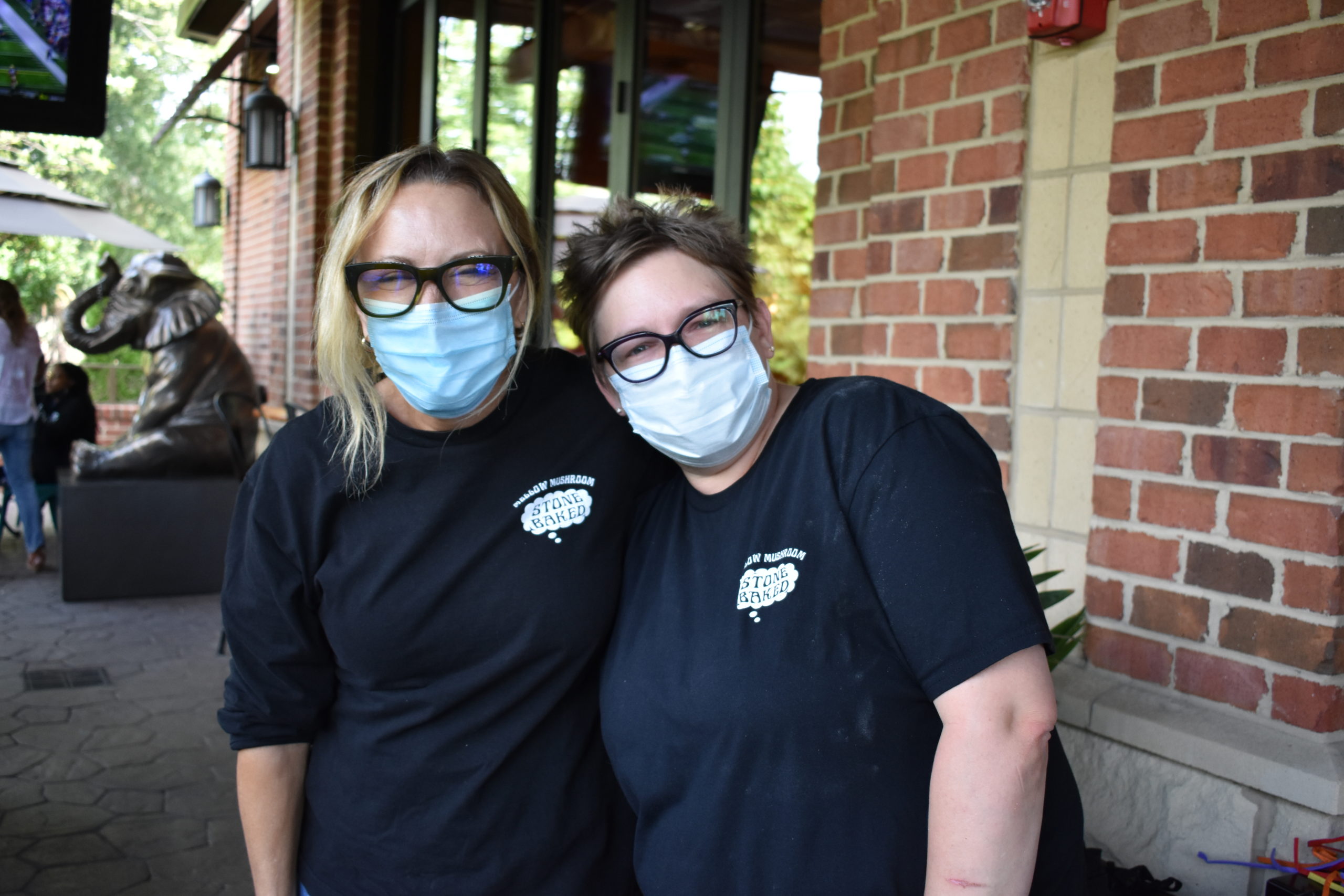 Image two people wearing face masks and shirts for Mellow Mushroom
