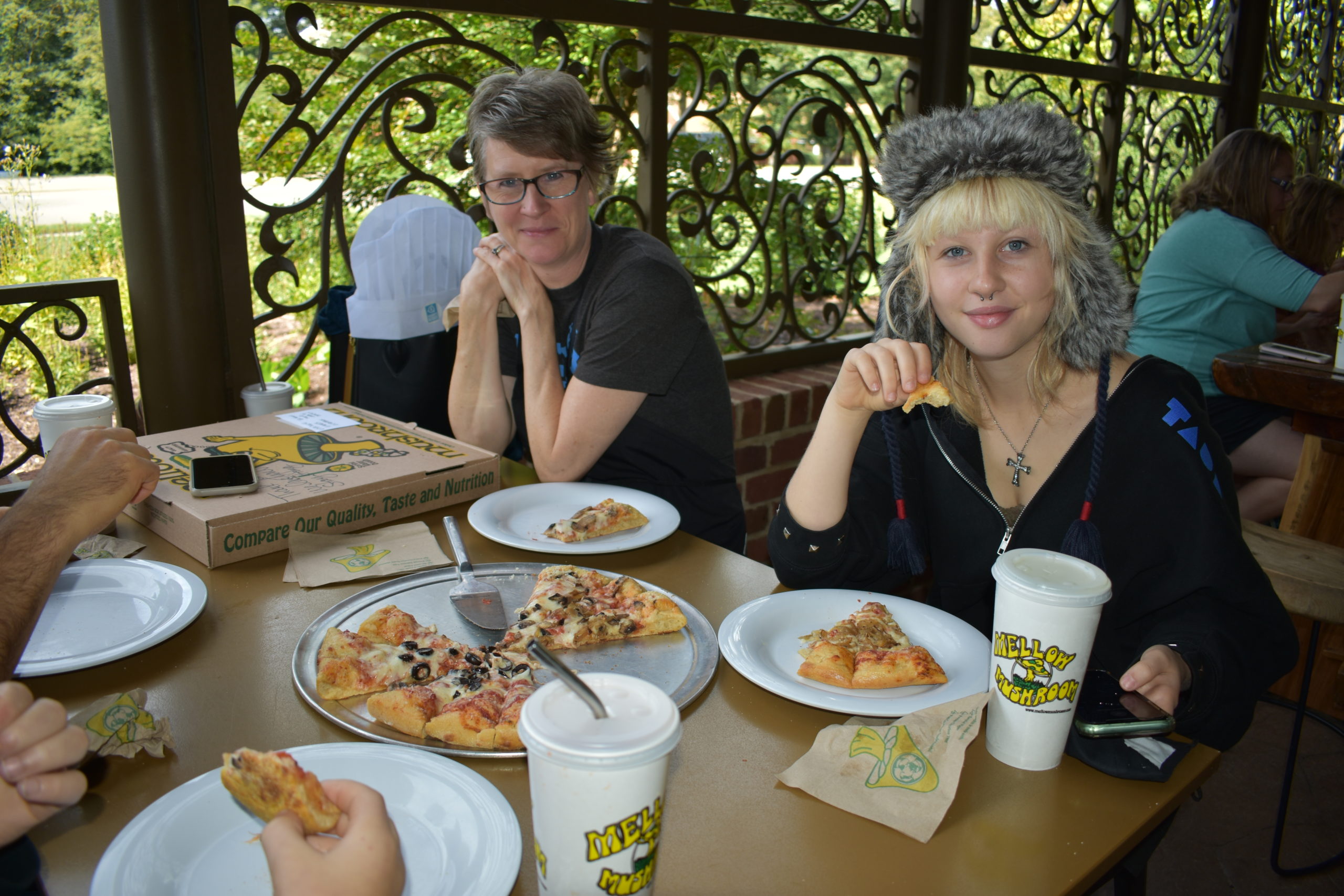 Image a parent and teen eating pizza