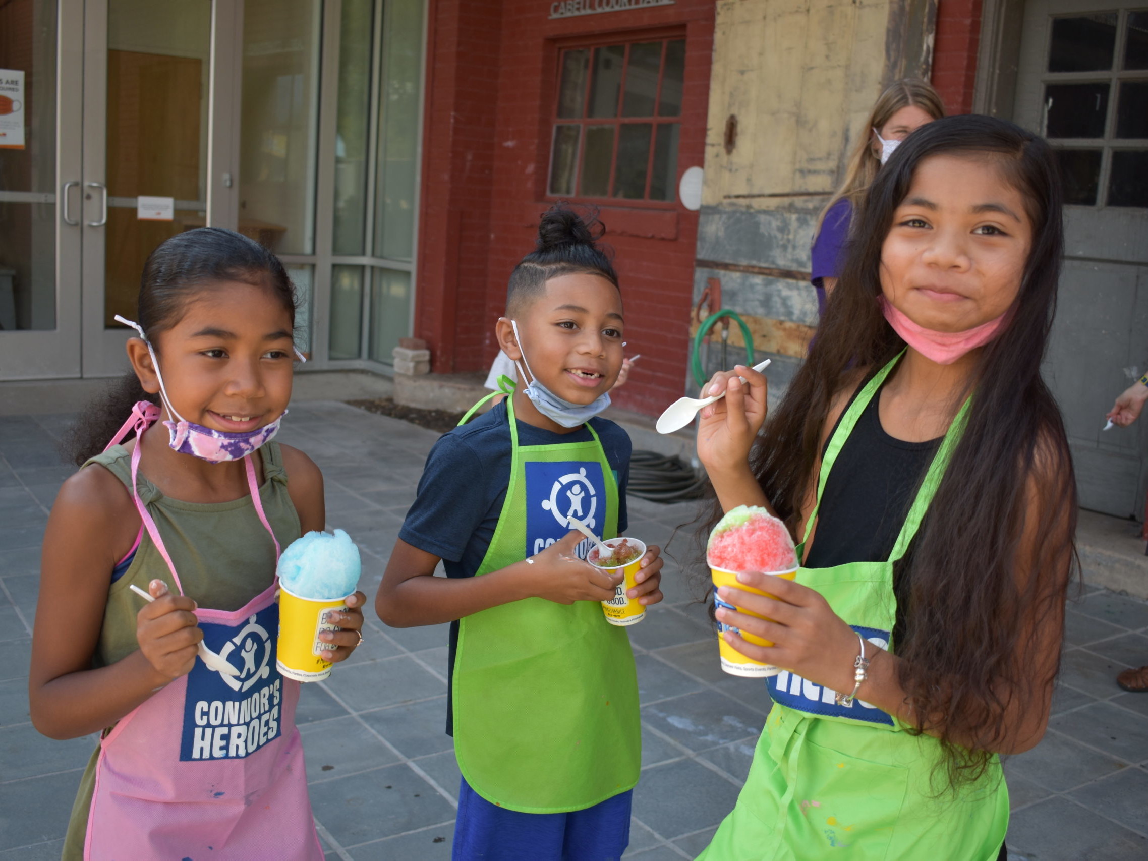 Image three children eat cups full of ice cream