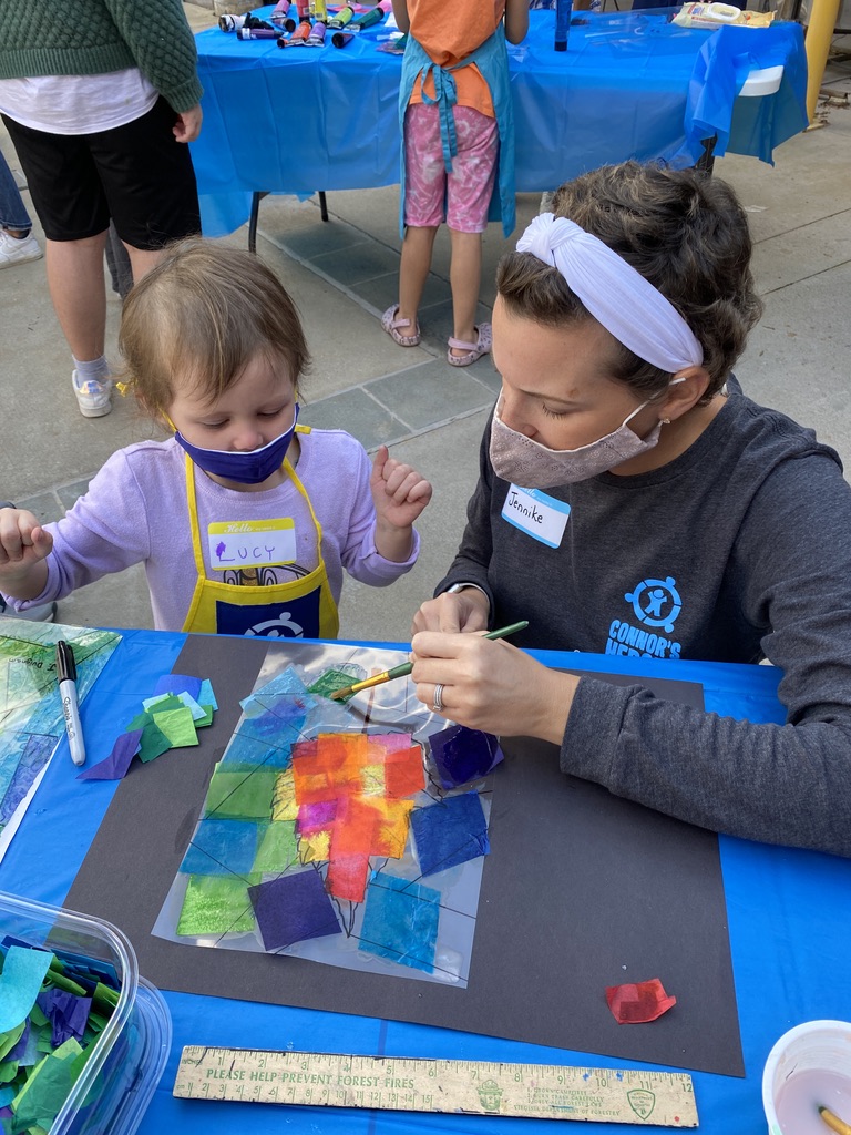 An adult helping a child work on a craft project