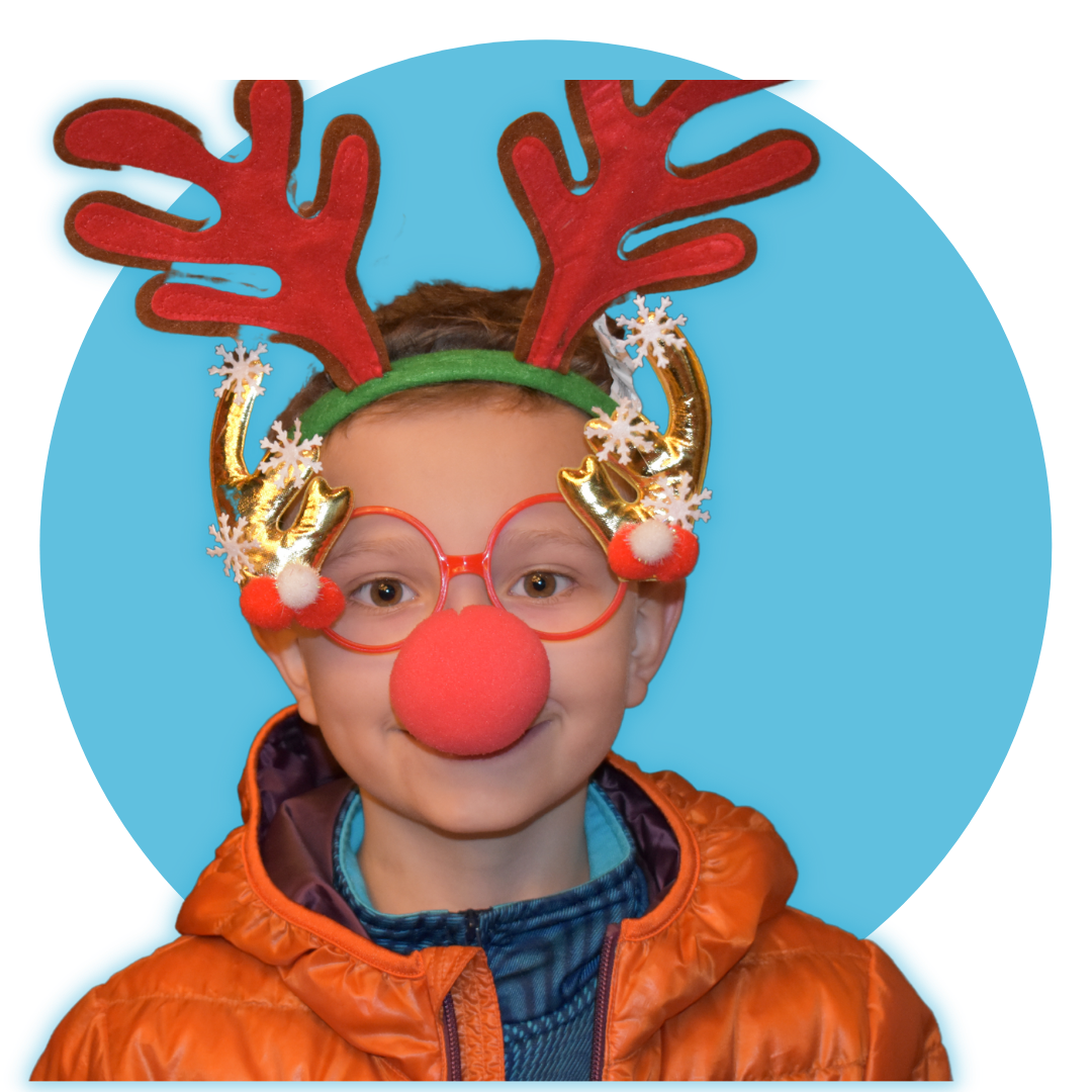child wearing cloth reindeer antlers and a large red nose