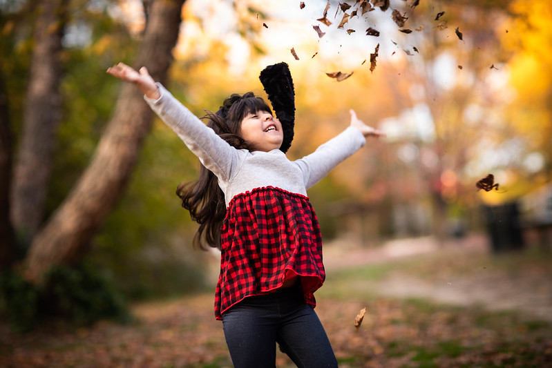A little girl throwing leaves in the air