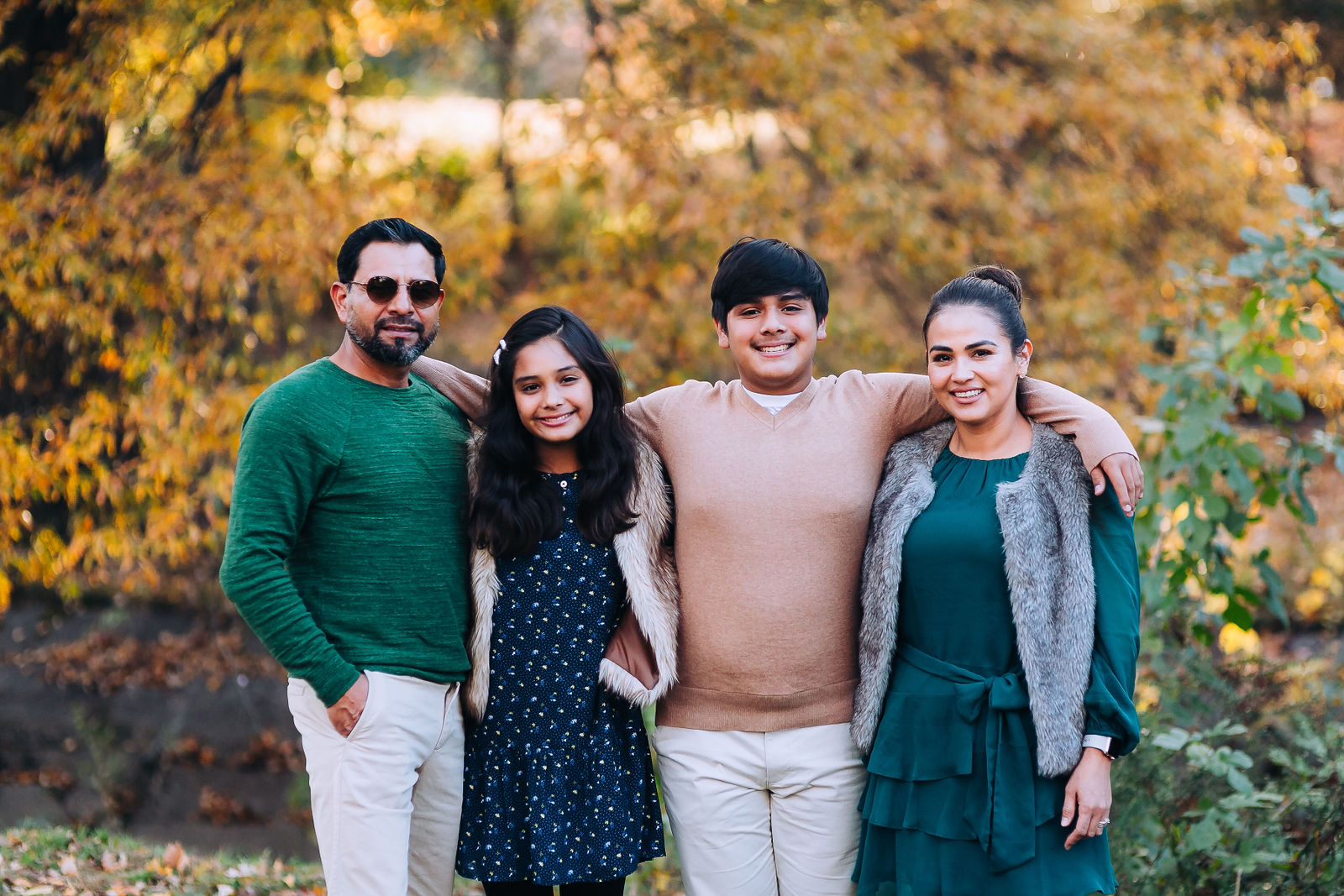 A picture of a family standing together in a park
