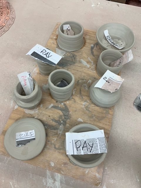 8 pieces of clay shaped into bowls sitting on a table