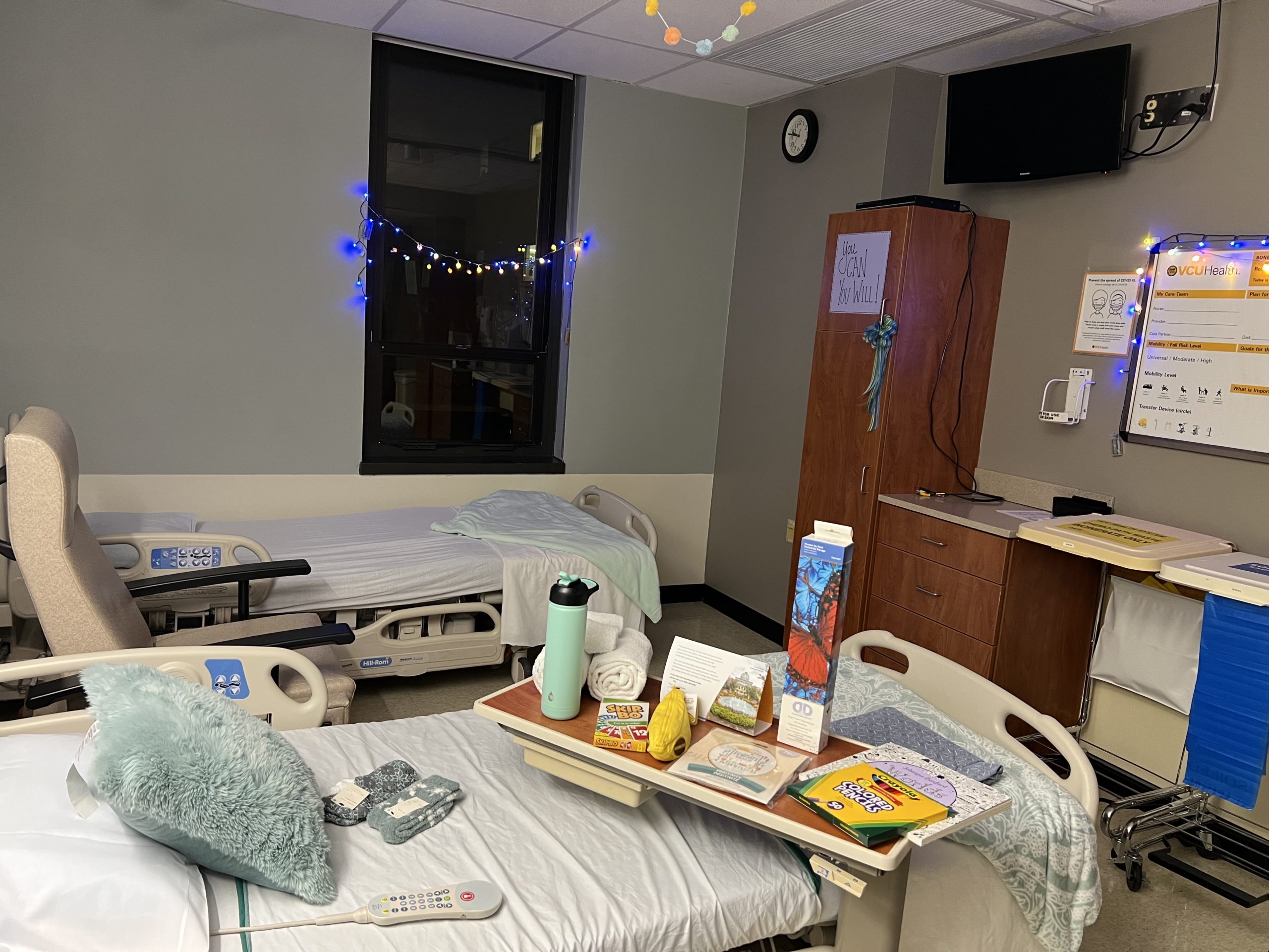 A hospital room with arts and crafts on the bedside table