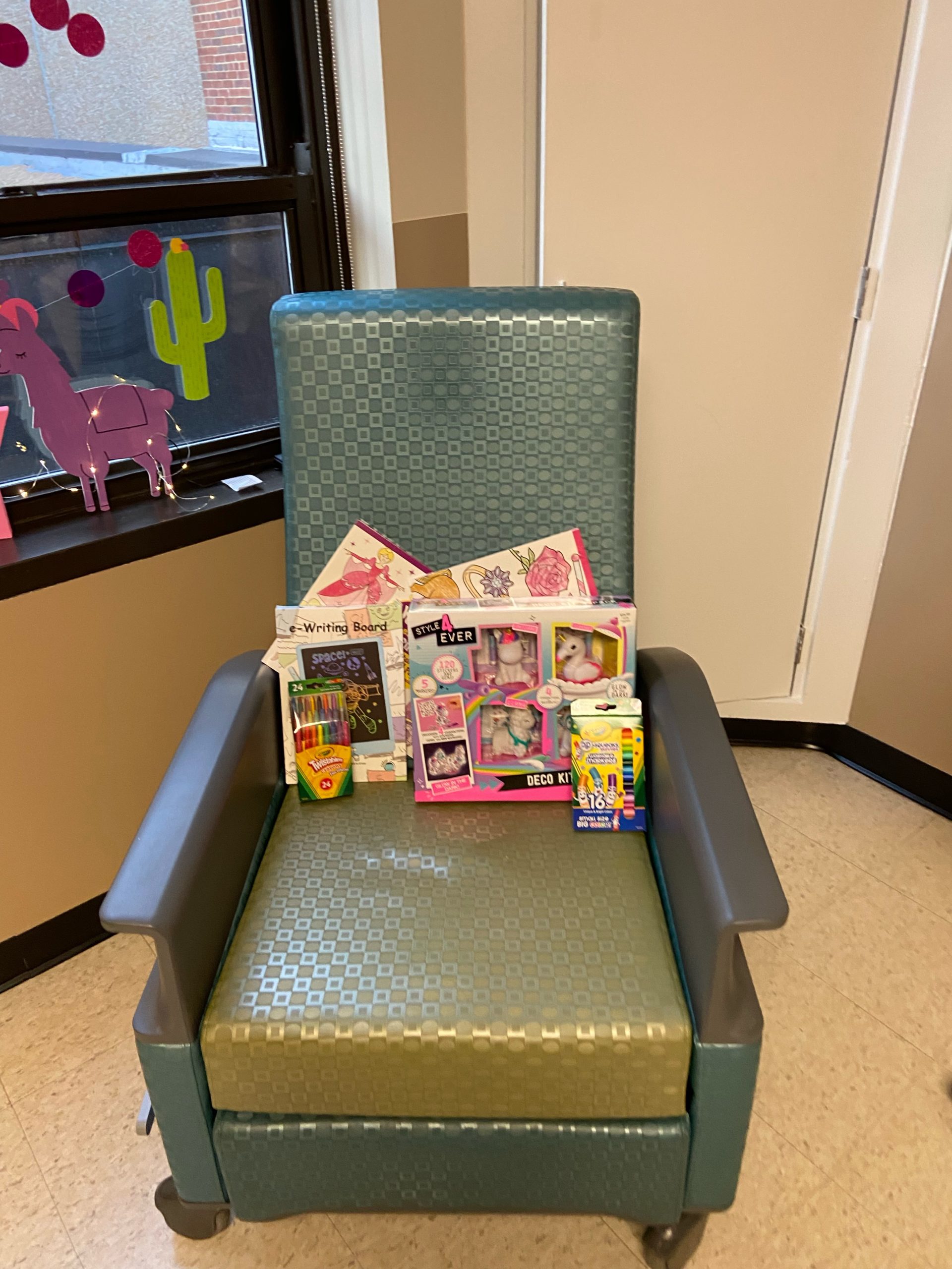 sitting on the seat of a green chair is a pile of activity books
