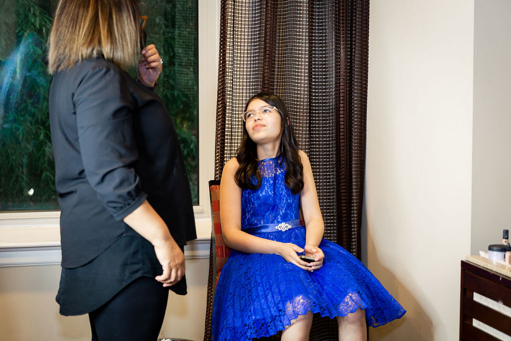 A girl wearing a blue dress talks to someone