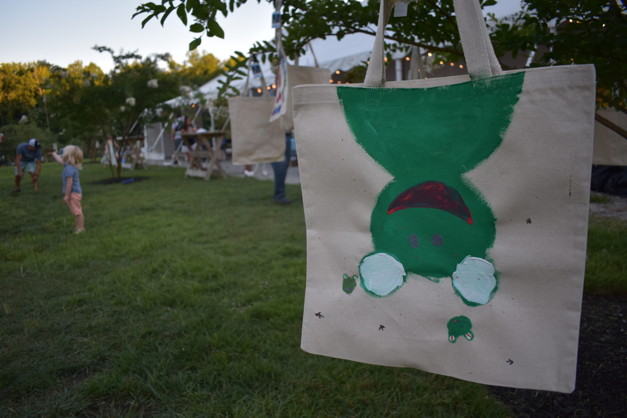 A close up of a totebag with a green front painted on it