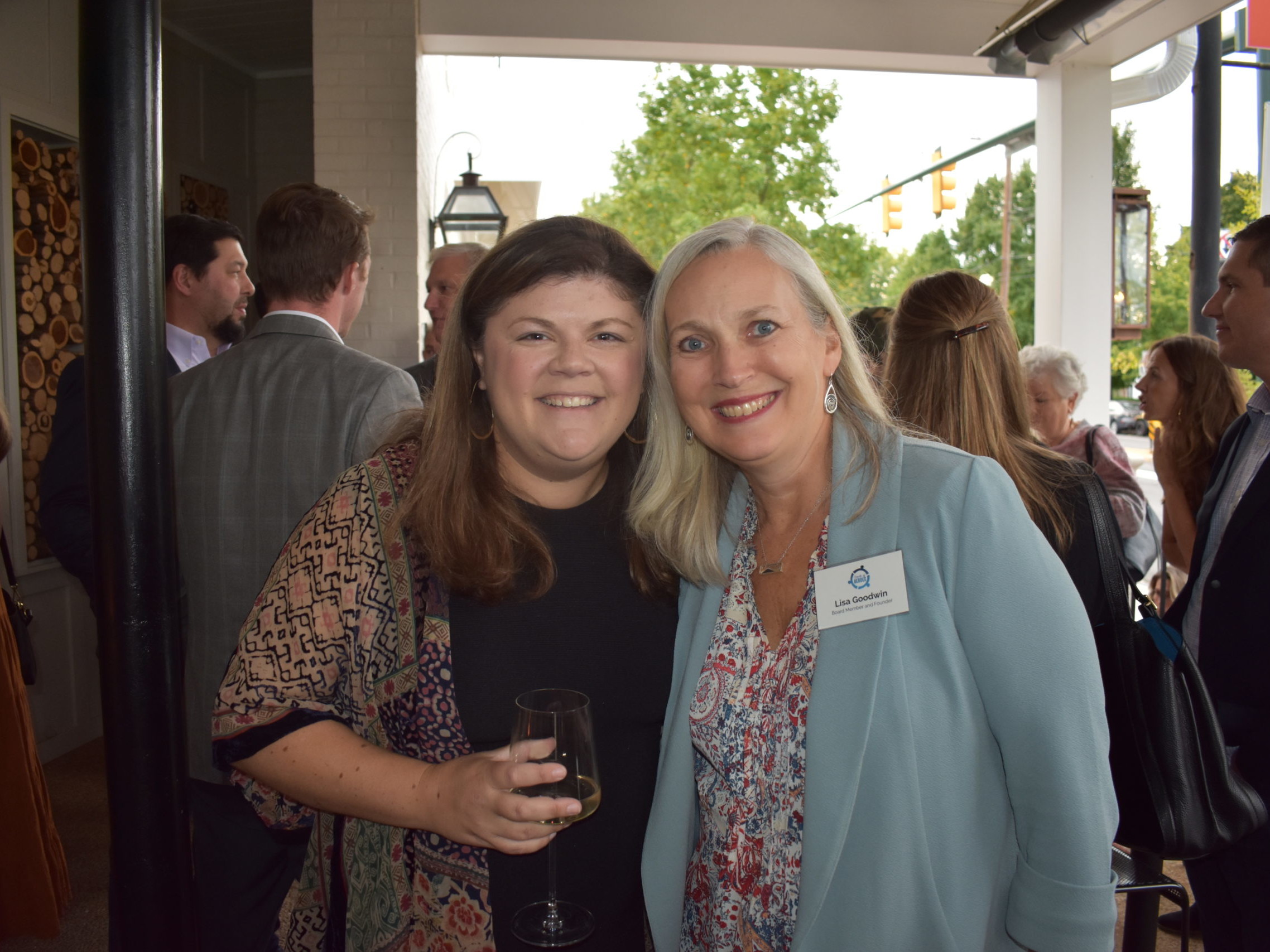 Two women are standing together on a patio