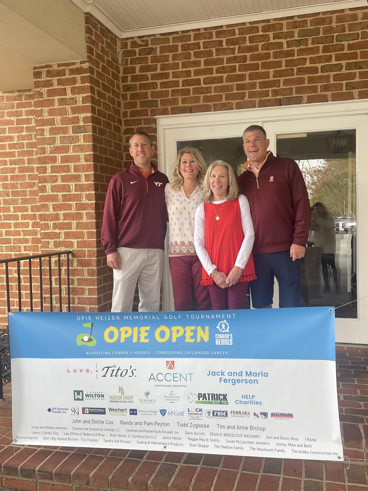 Four people standing together in front of a banner Opie Open