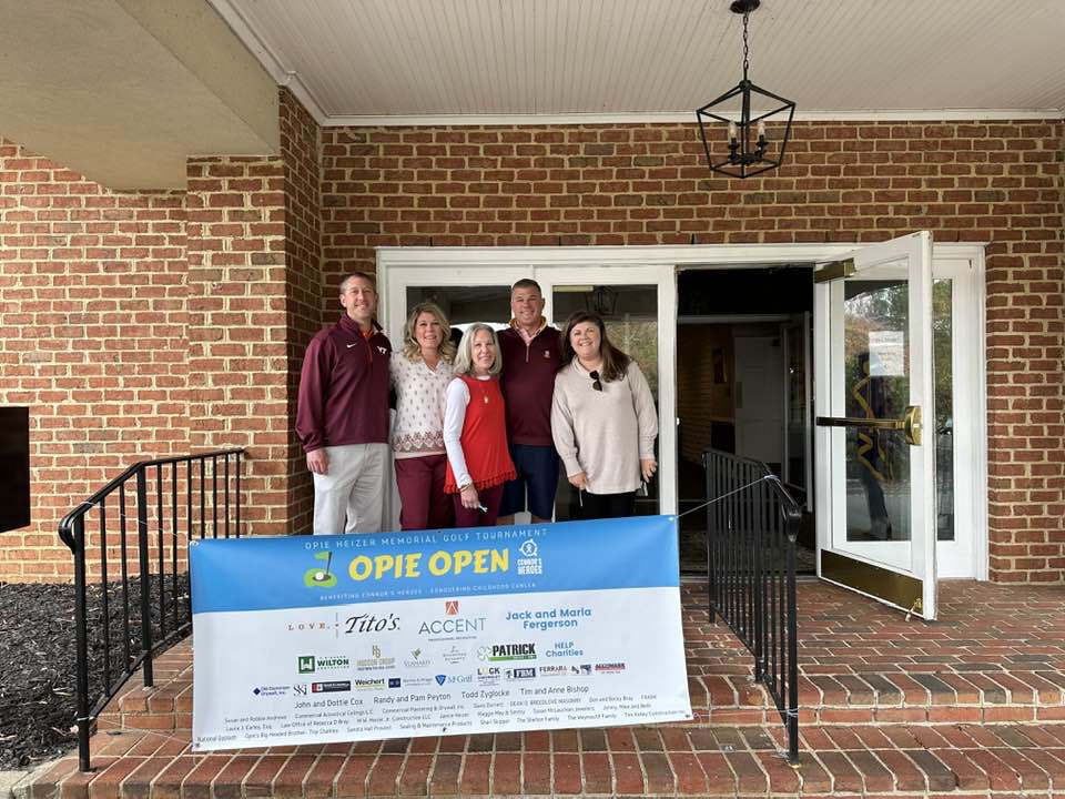 Five people standing together in front of a banner saying Opie Open