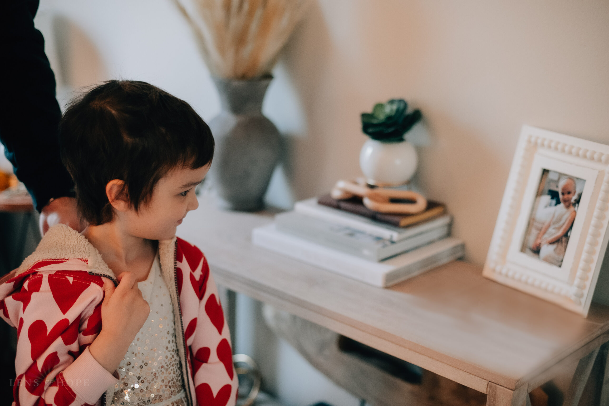 Ava looking at a photo of herself taken when she started her cancer treatment