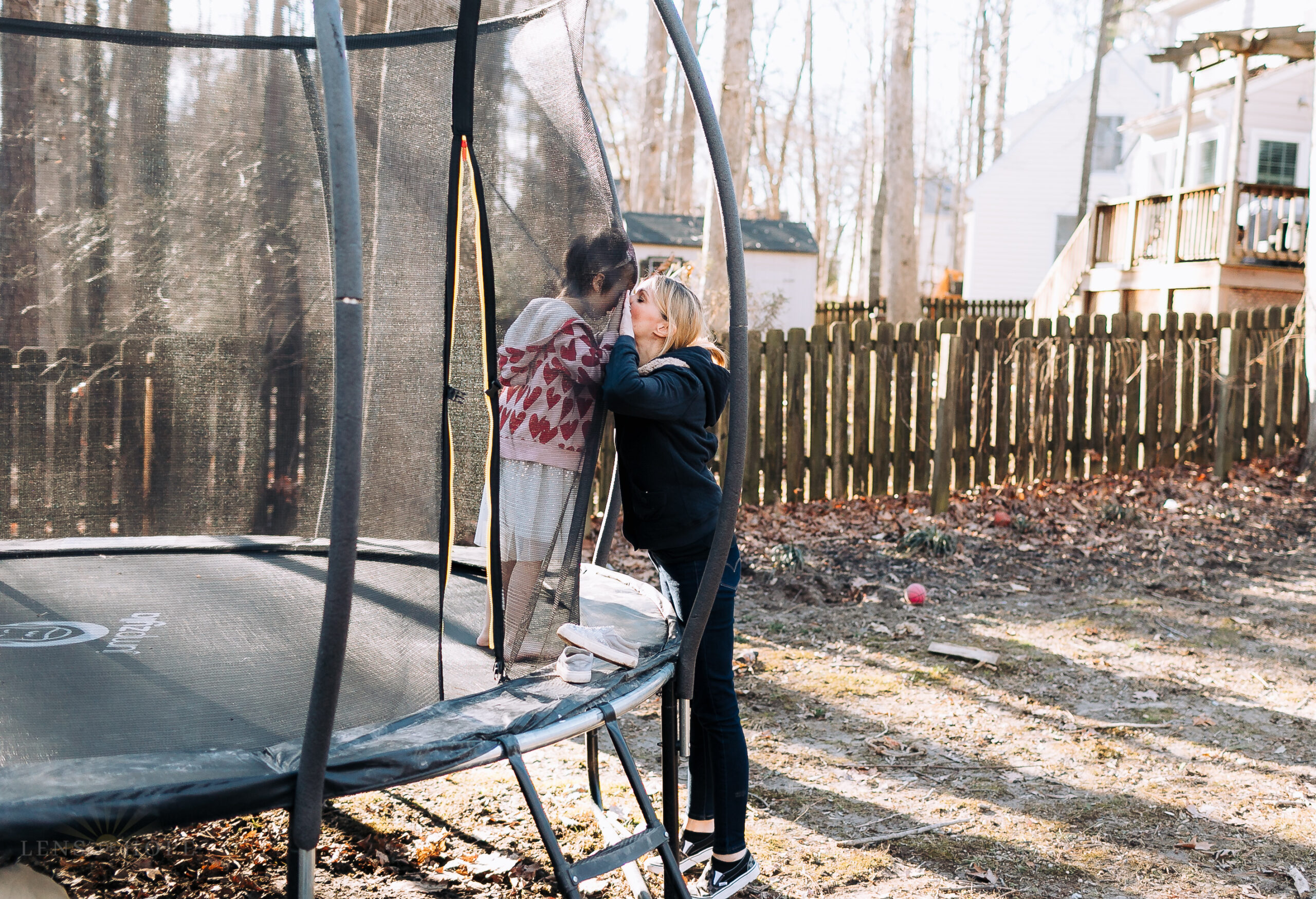 Ava standing in a trampoline while her mom is standing outside of the trampoline