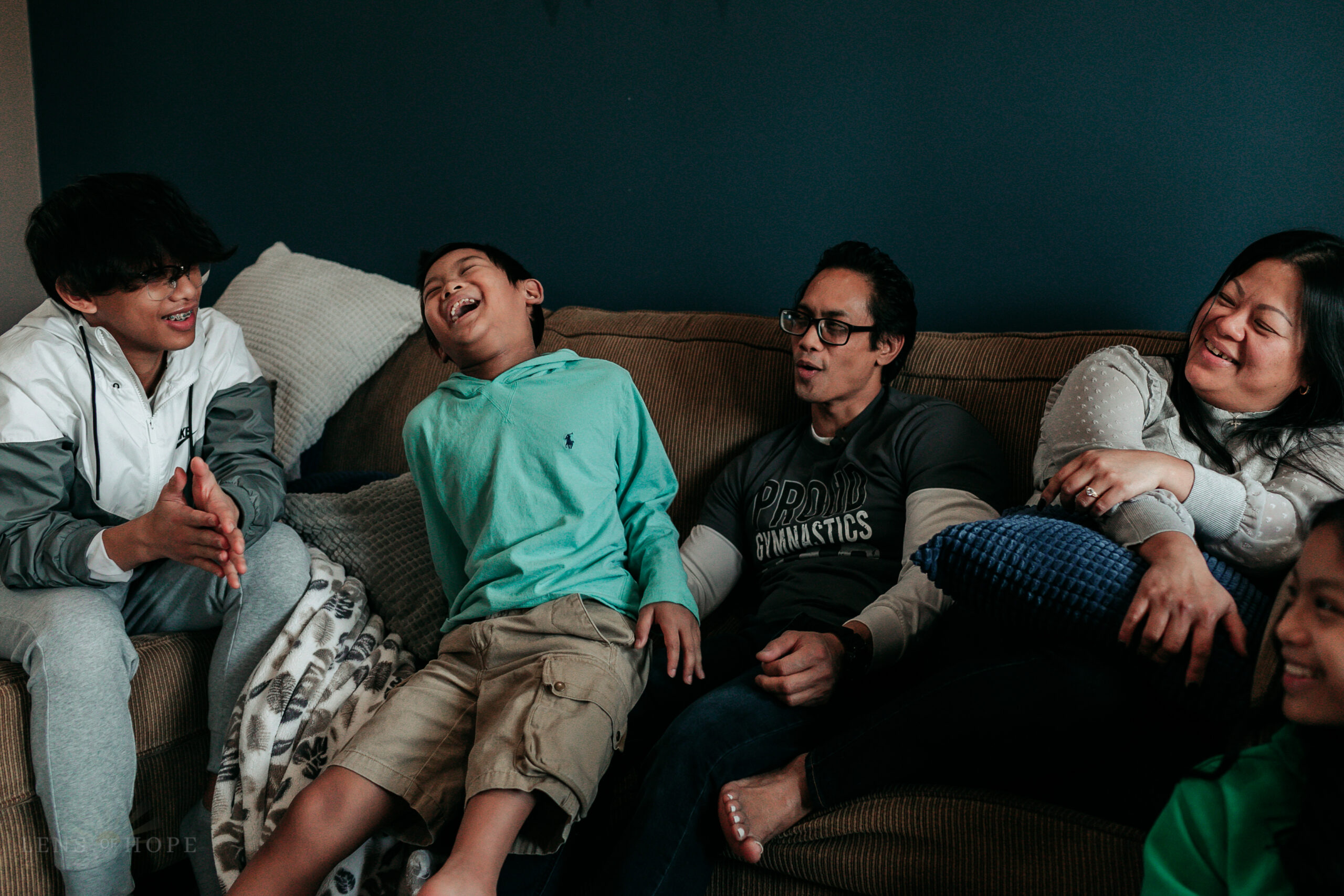 five people are sitting on a couch they are a family