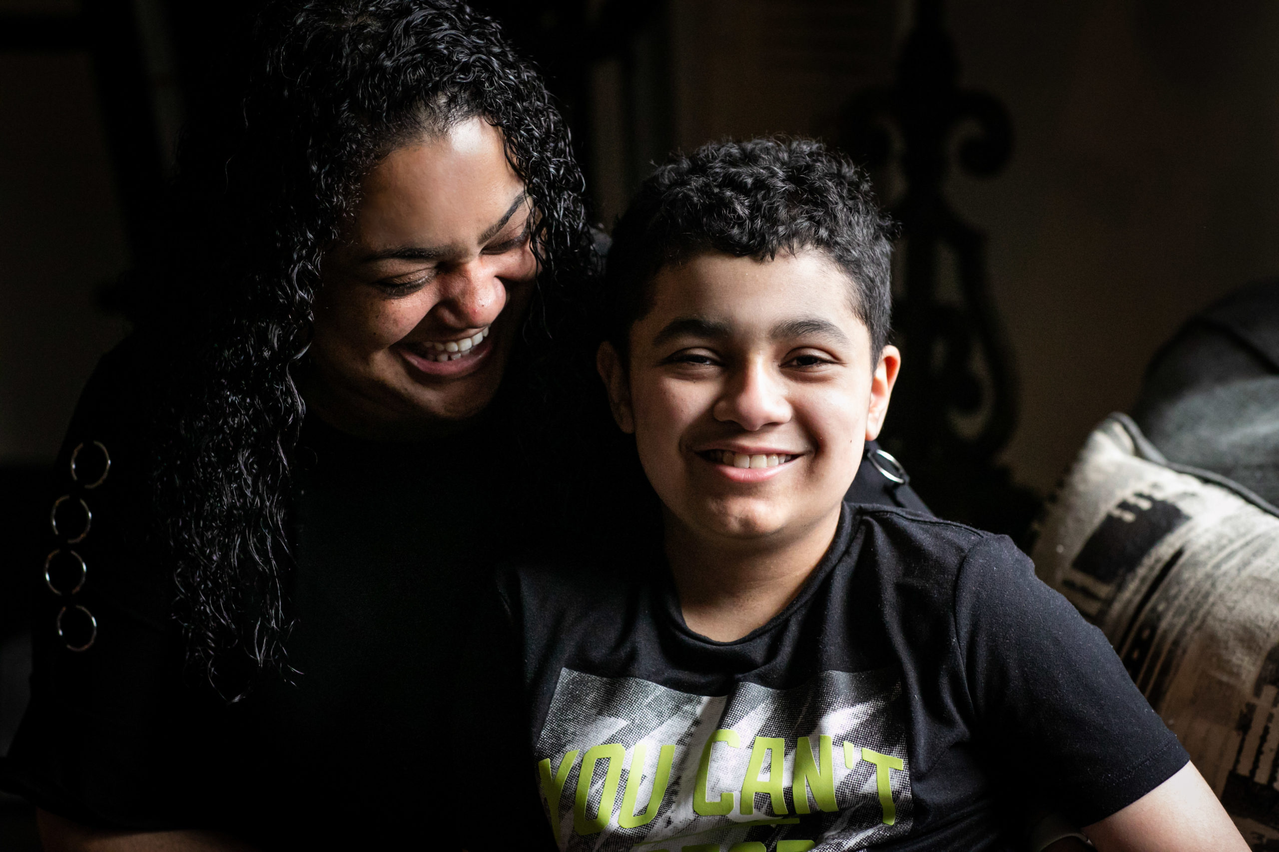 Isaiah is sitting with his mom who looks at him smiling