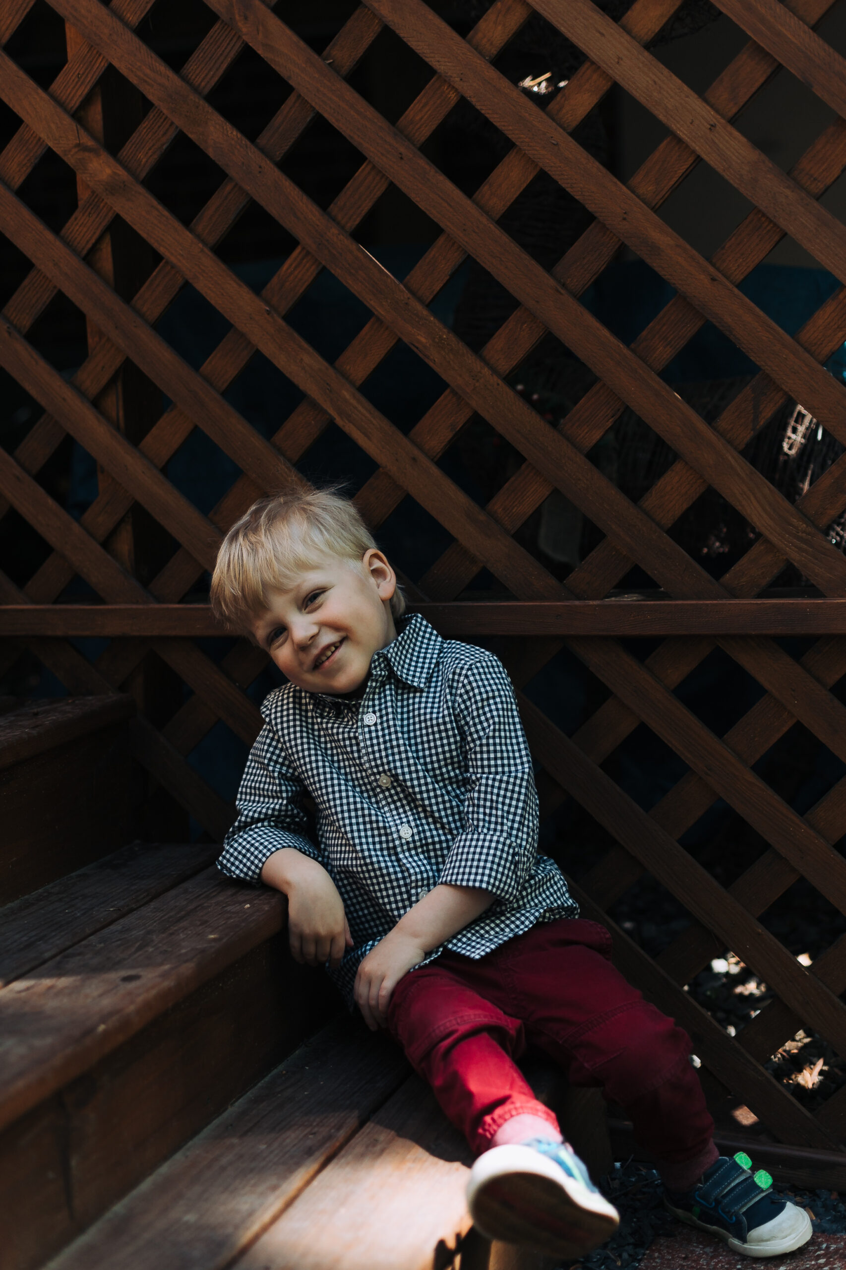 James sitting on the steps outside in the sun smiling