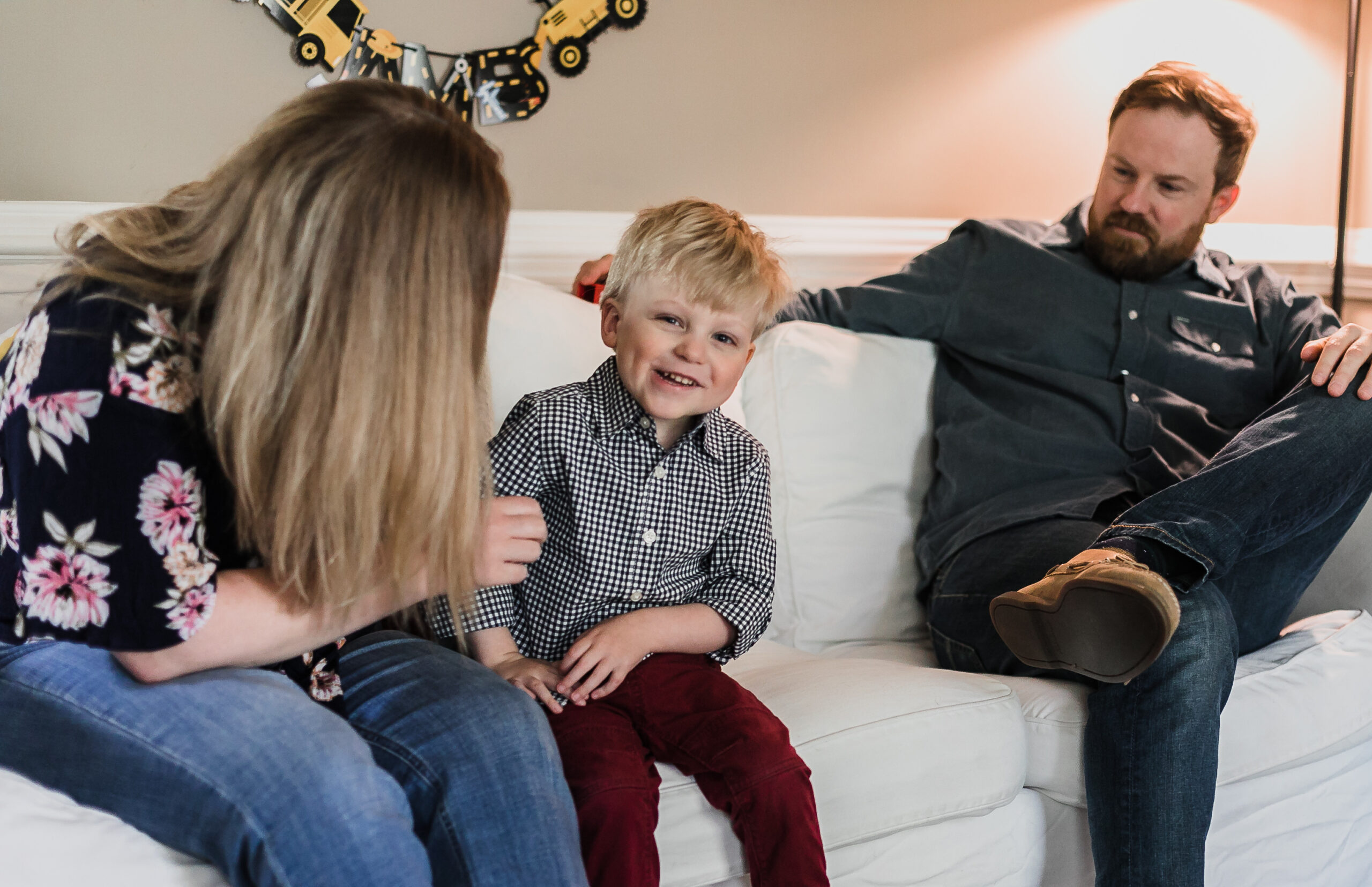 James sits on the couch with his mom and dad