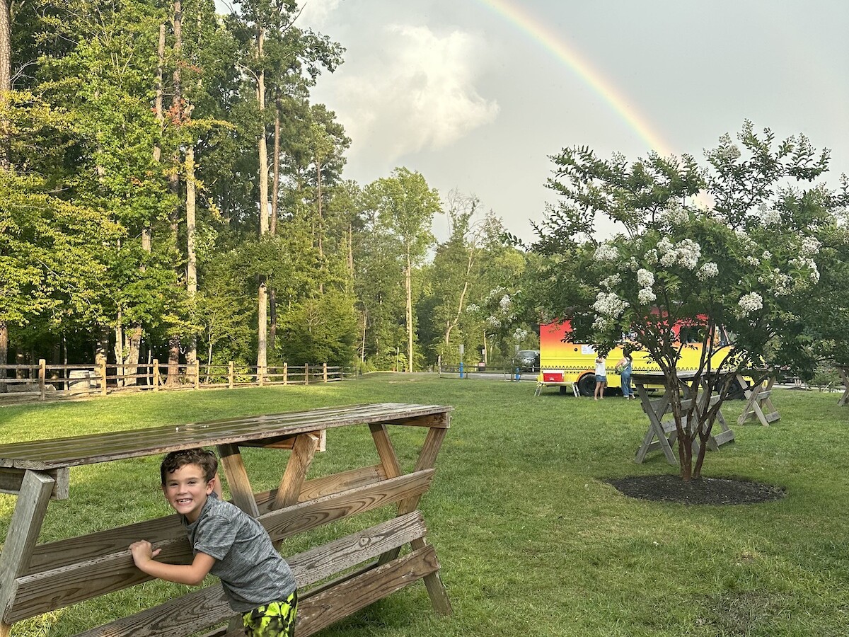 A boy plays under a rainbow