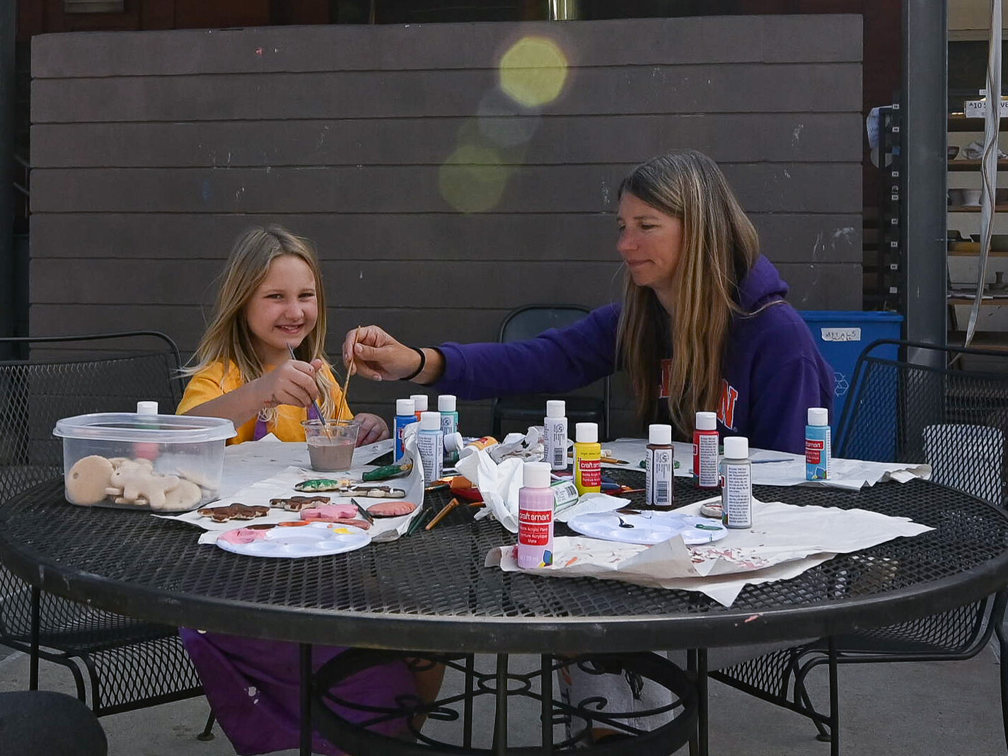 A mom and her daughter are painting together